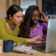 Two Women Using A Laptop To Manage Their Home Finances And File Taxes
