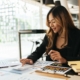 Business Person With Calculator Looking At Charts And Graphs